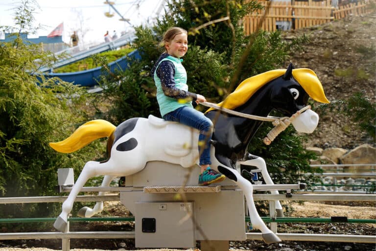 Yakari Erlebniswelt Pferdebahn mit kleiner Donner und Kind im Fort Fun