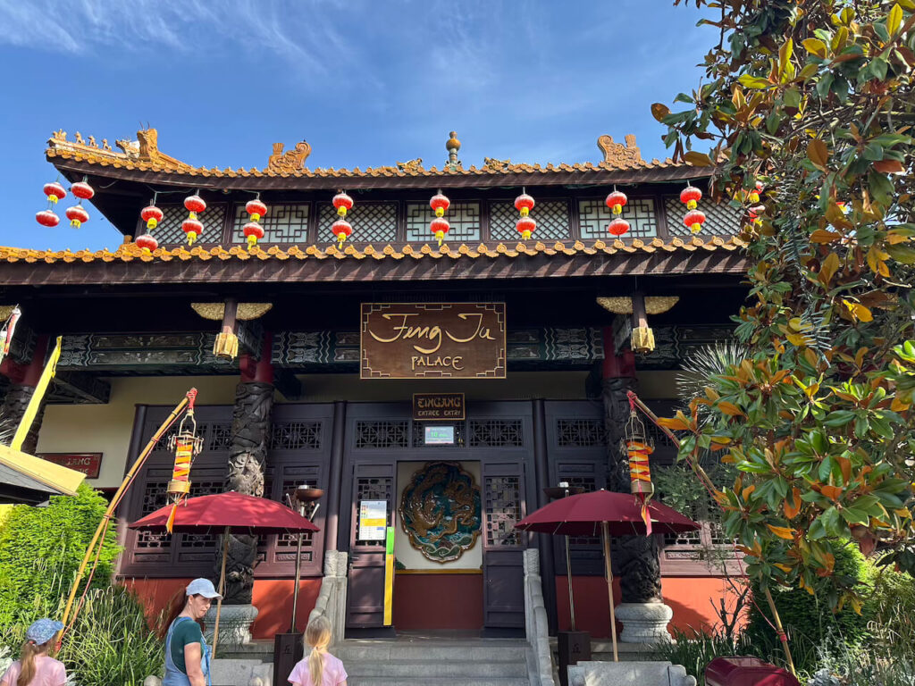 Der Eingang des Feng Ju Palace mit geschwungenem Pagodendach, roten Lampions und einem großen Drachen-Relief über der Tür.