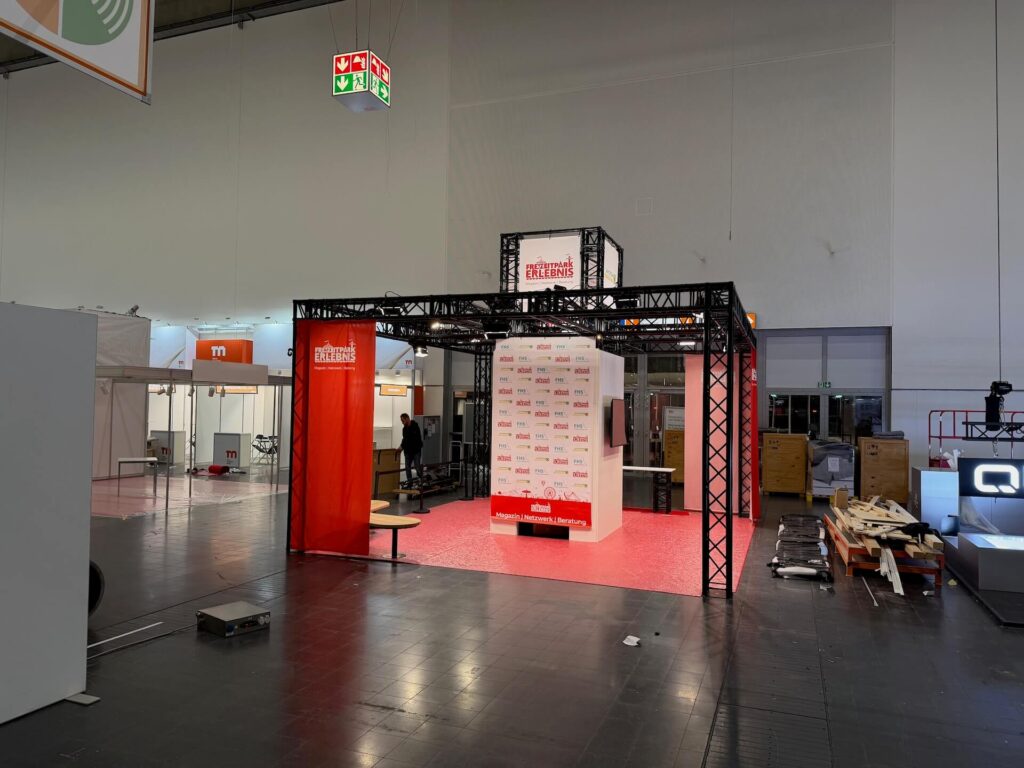Aufbau Messestand mit Traversensystem und Banner Freizeitpark Erlebnis sowie Sponsoren Wand mit Logos von hidden disabilities sunflower und FHS Holztechnik